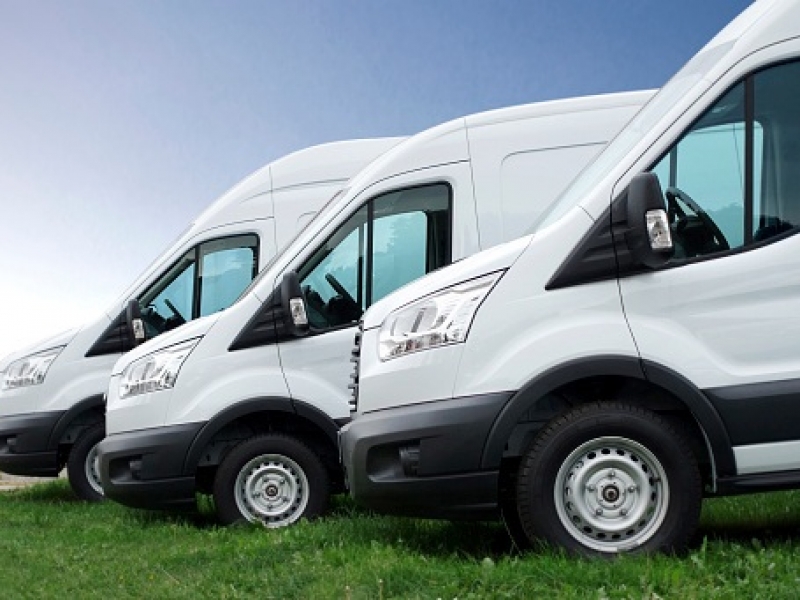 White vans in a row against blue sky